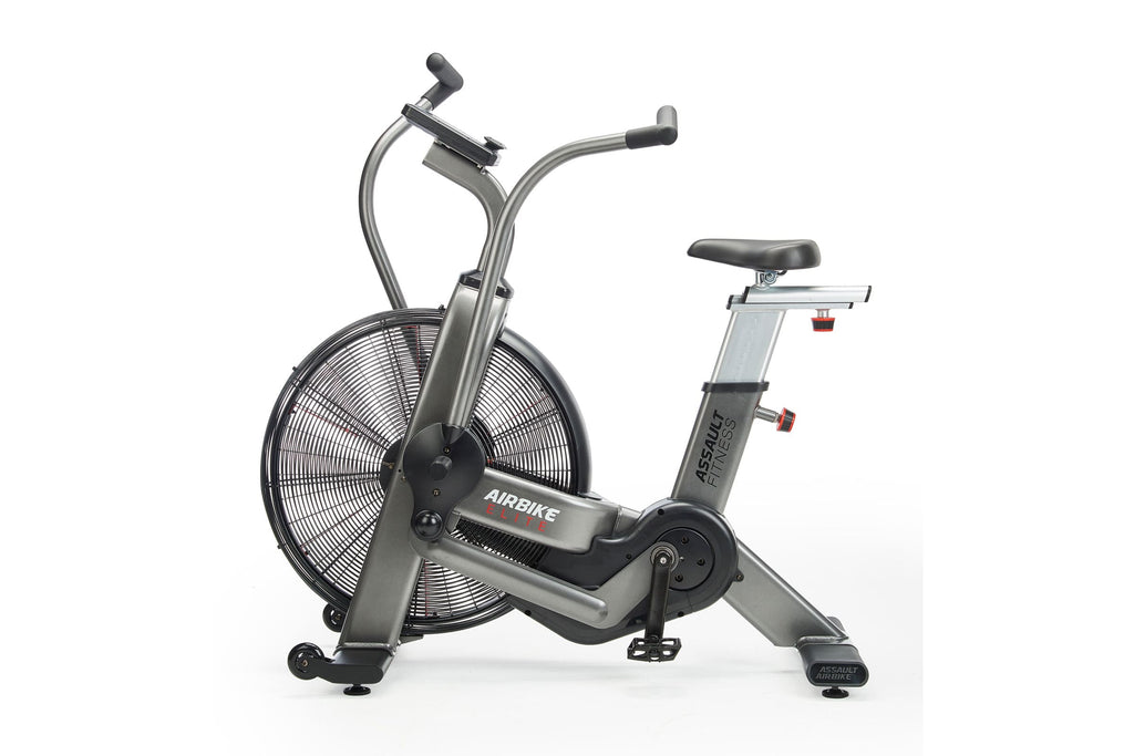 Assault Elite Air Bike with silver frame, large black fan wheel, dual handlebars, and black padded seat on white background