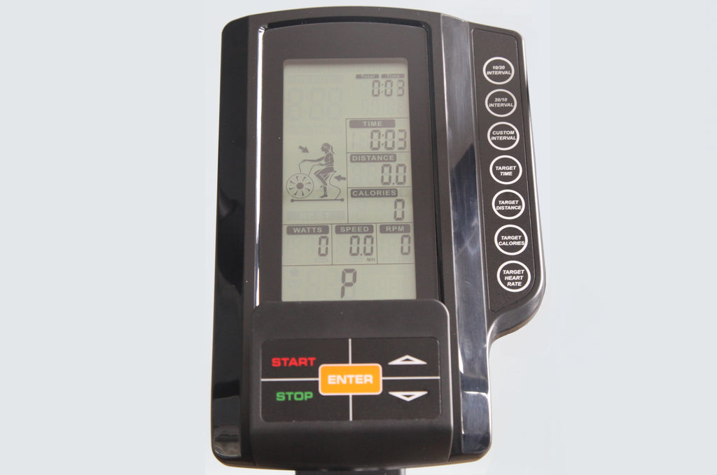 Black exercise bike console with LCD display showing time, distance, calories, watts, speed and RPM metrics, featuring orange