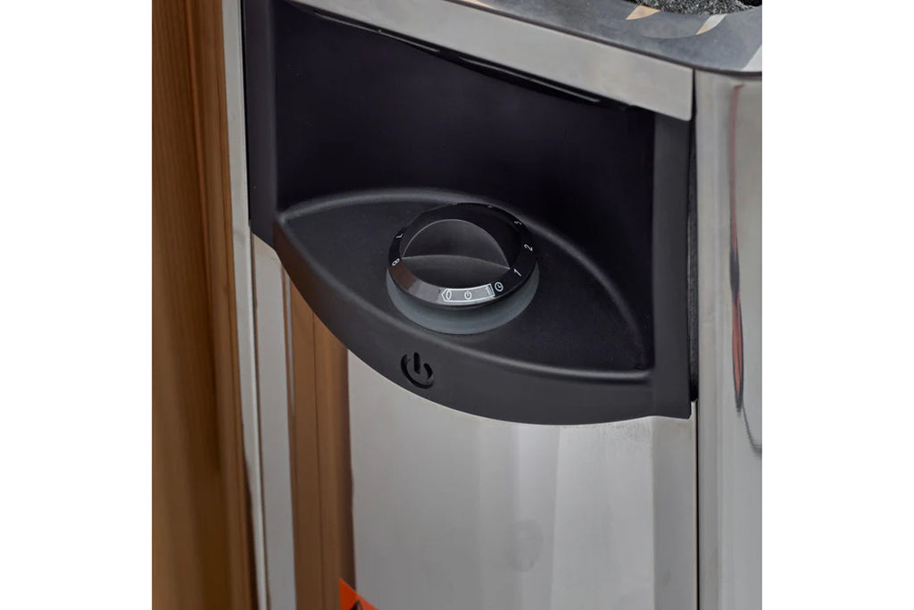 Black and silver sauna heater control panel with dial knob mounted on curved housing, installed in sauna interior