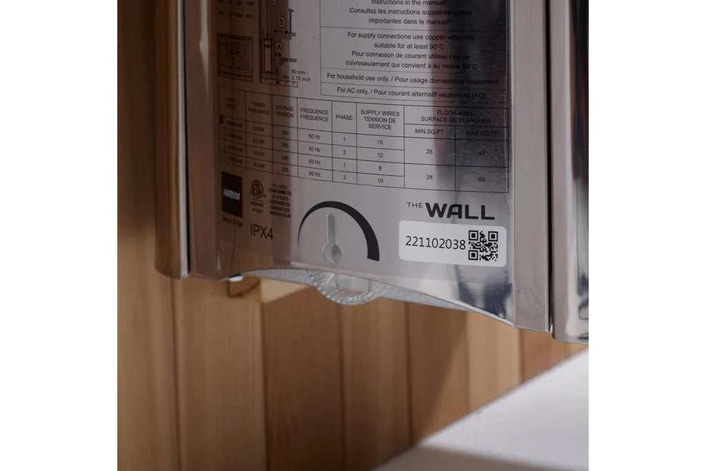 Close-up of sauna instruction label showing technical specifications table, IPX4 rating, QR code, and The Wall branding on me