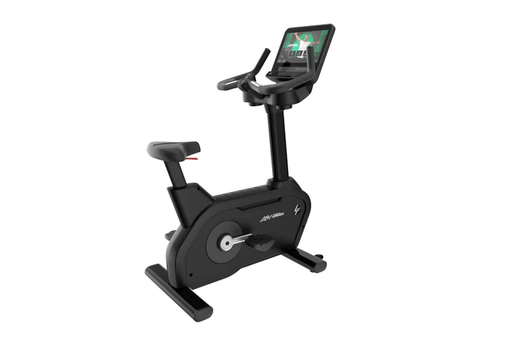 Black upright exercise bike with digital touchscreen display, handlebars, and seat on white background