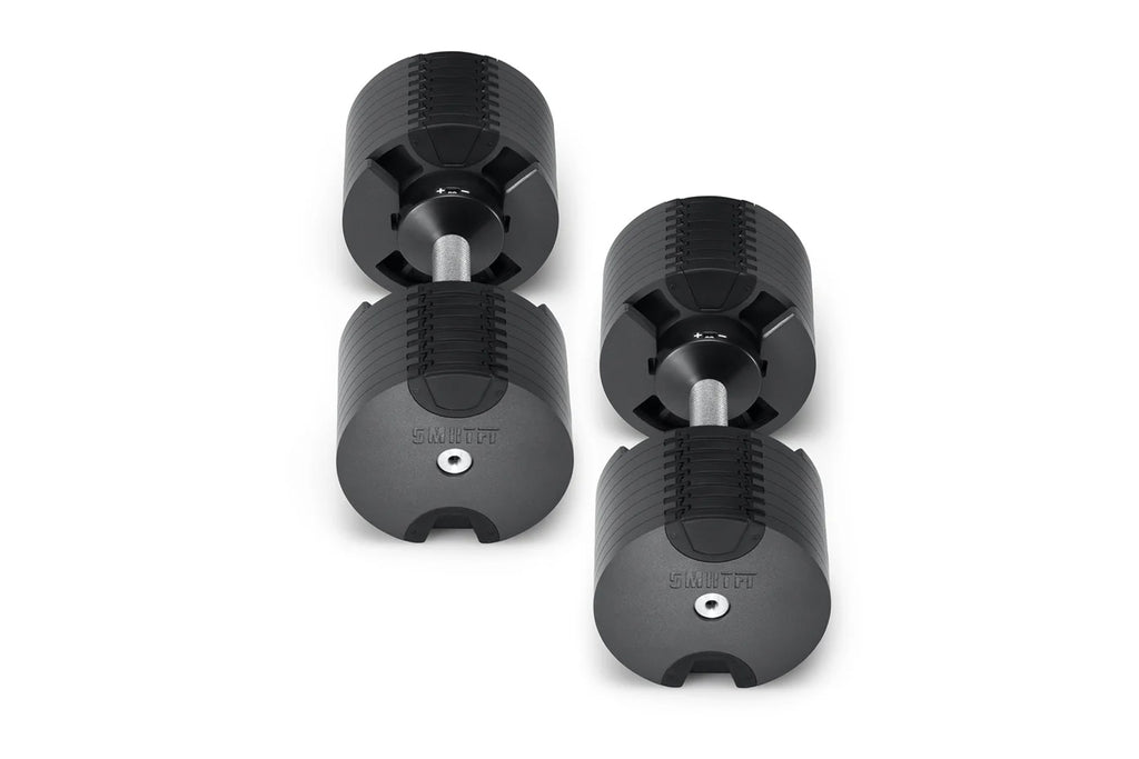 Pair of black NÜOBELL adjustable dumbbells with textured rubber grip and metal handles on white background