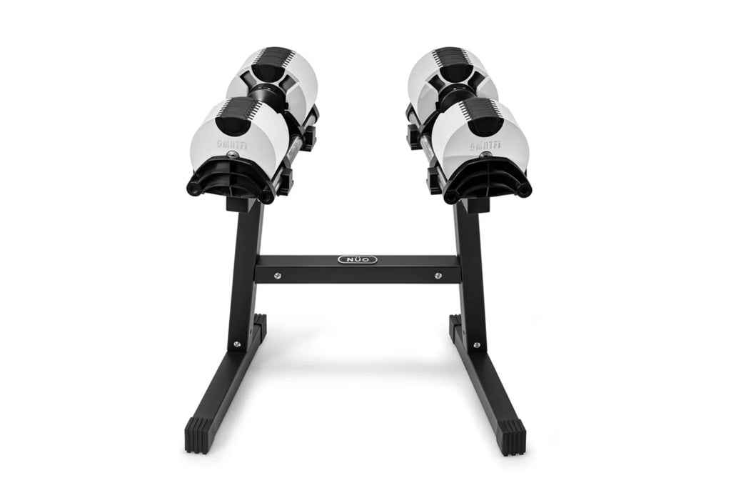 Pair of Nüobell adjustable dumbbells in white and black on black stand, flat lay on white background