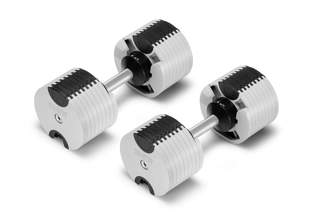 NÜOBELL adjustable dumbbells with white and black grooved plates, silver handles, shown as pair on white background