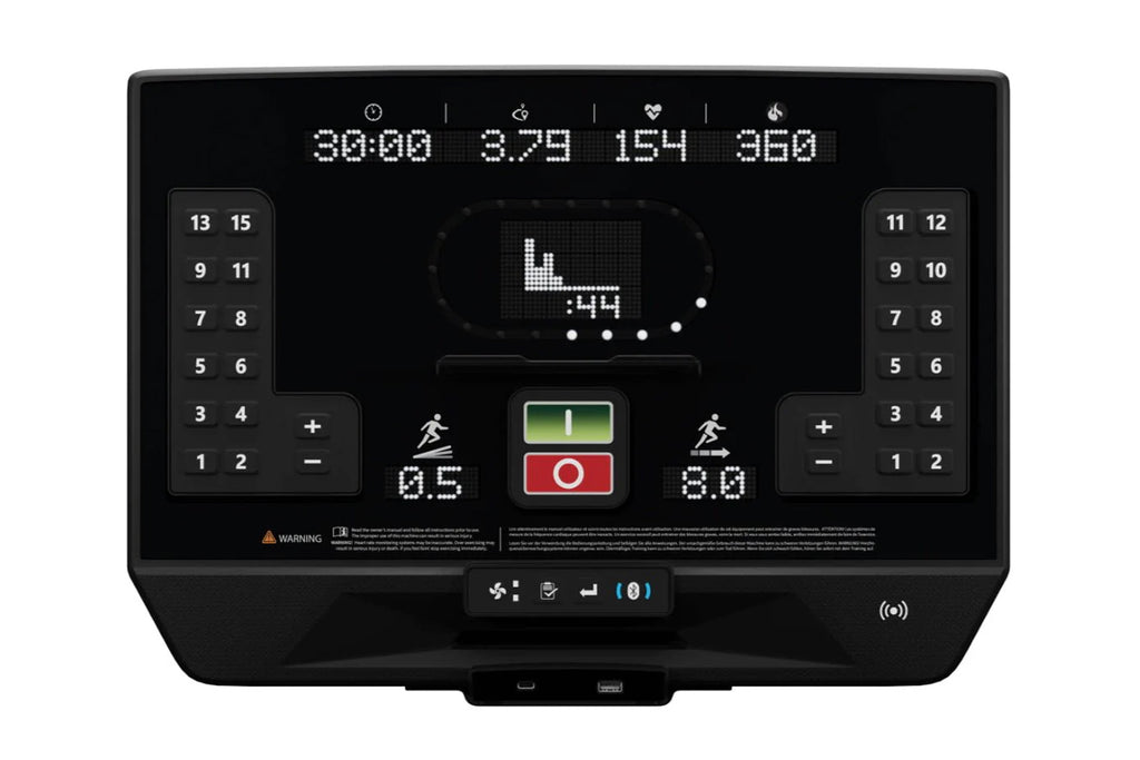 Star Trac 8TR treadmill console display with digital metrics, numeric keypads on sides, and central control buttons on black 
