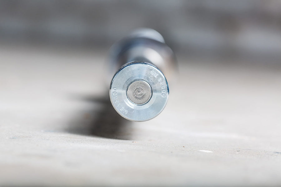 Silver metal barbell end cap with circular center detail, close-up view on white surface